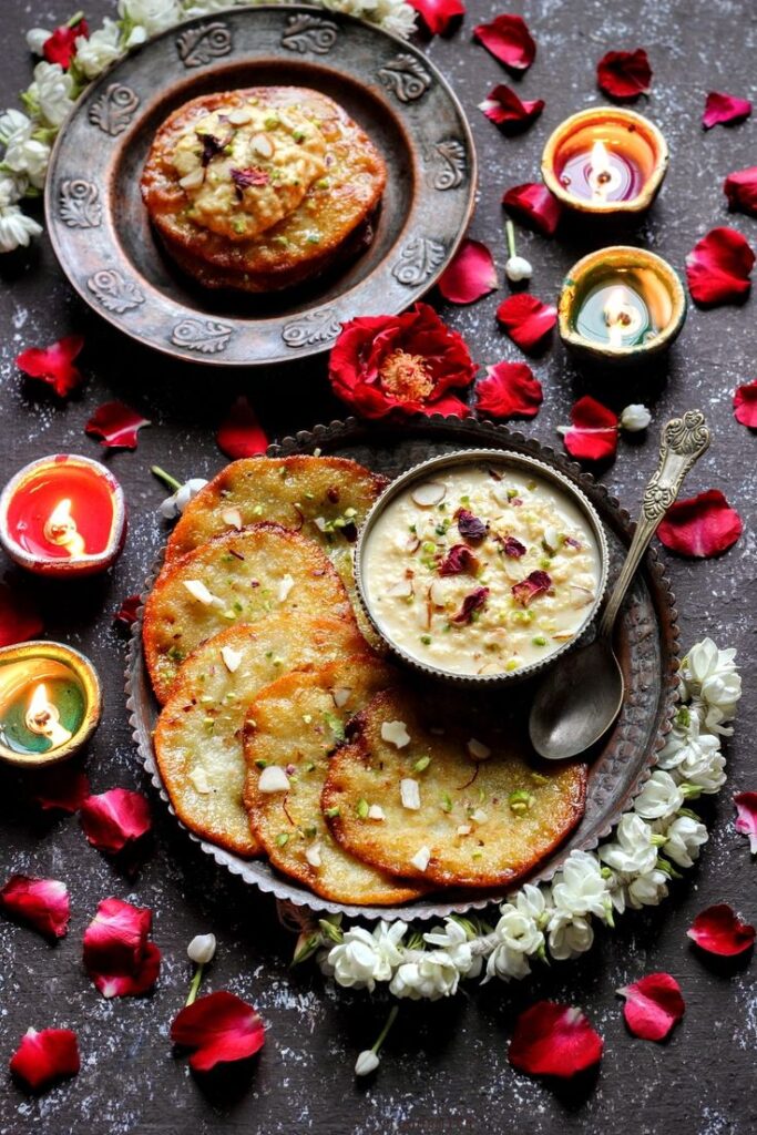 Golden fried malpua topped with creamy saffron rabri and nuts
